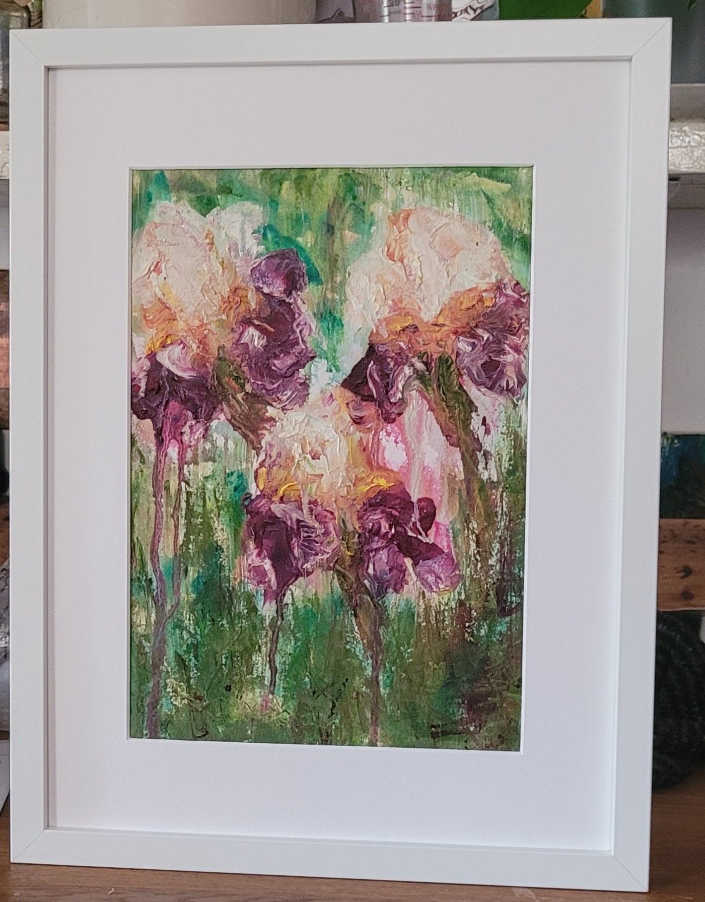 Oil Painting of Iris Flowers against an abstract green garden background in a white frame