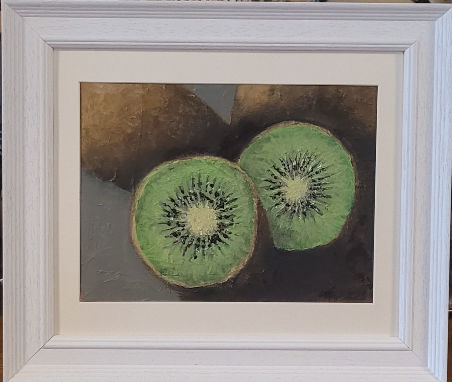 Oil Painting of 3 kiwi fruit, one cut in half, in a white frame